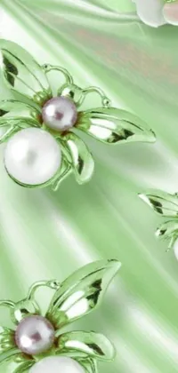 This phone live wallpaper boasts a green backdrop splattered with pearls and white spring flowers
