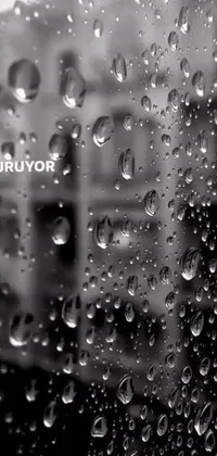 This live wallpaper features a captivating black-and-white photograph of water droplets cascading slowly down a window pane
