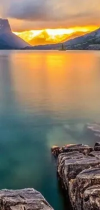Experience the natural beauty of a magnificent mountain range and a sparkling body of water with this stunning phone live wallpaper