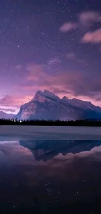 This phone live wallpaper showcases a picturesque landscape of a serene body of water with a grand mountain range in the background