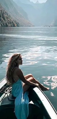 Add serenity to your phone screen with this live wallpaper of a woman paddling a boat in a lake surrounded by vibrant foliage
