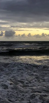 This phone live wallpaper captures an awe-inspiring moment of a surfer surfing a wave in the ocean at sunrise or sunset