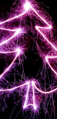 This Christmas-themed live wallpaper features a sparkler-made tree on a black background, accompanied by bright pink and purple lights