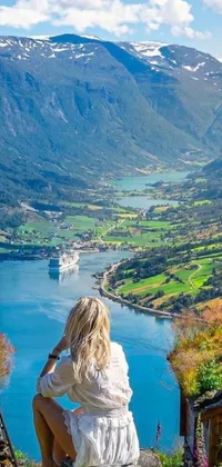 This phone live wallpaper depicts a woman enjoying the serene scenery of Norway fjords, surrounded by picturesque views of fall foliage