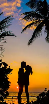 Bring a touch of tropical romance to your phone with this stunning live wallpaper! The perfect combination of love and beauty, this wallpaper shows a couple standing in front of a breath-taking sunset in a tropical setting