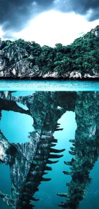 Bring a stunning and mystical live wallpaper of a large rock formation surrounded by water to your phone
