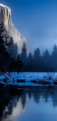 This stunning live wallpaper features a majestic mountain covered in snow, a tranquil river, and lush meadows, all set against a romantic dark blue mist