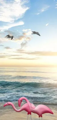 This phone live wallpaper showcases a picturesque beach with pink flamingos standing gracefully on the sand, a flying whale in a clear blue sky, and a photorealistic, pink sphere hovering in the clouds
