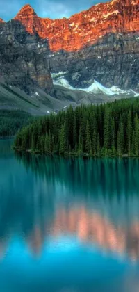 Enjoy the mesmerizing beauty of nature with this live wallpaper showcasing a serene lake and a mountain backdrop in vivid colors