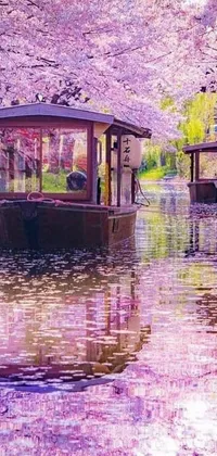 Decorate your phone with this live wallpaper featuring boats floating on a river amidst falling cherry blossom petals and shady trees