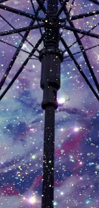 This phone live wallpaper showcases a close-up shot of an umbrella against a beautiful sky background, incorporating space art and a glitter gif for a stunning effect