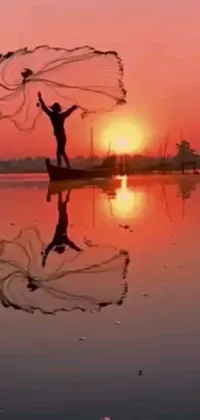 This live wallpaper features a breathtaking scene of a man standing on water with a net in his hand against a mesmerizing red and pink sunset