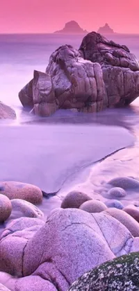 This live wallpaper for your phone showcases a peaceful beach with rocks resting on the shore
