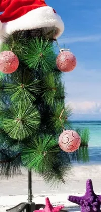 This phone live wallpaper presents a delightful digital illustration of a Christmas tree on top of a serene sandy beach