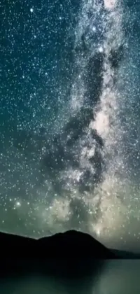 Get lost in the beauty of the night sky with this mesmerizing live phone wallpaper adorned with endless bright stars next to a serene body of water