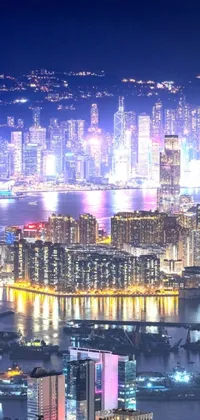 This phone live wallpaper shows an aerial view of a tech-focused city at night, similar to Hong Kong, with numerous multicolored illuminated buildings in the background