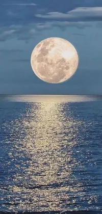 This phone live wallpaper displays a full moon rising above a water body with an elevator to the moon and playful emojis