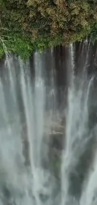 This live wallpaper displays an exquisite bird's eye view of a waterfall in an hurufiyya style