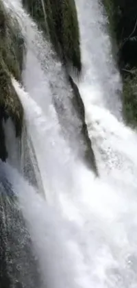 This dynamic phone live wallpaper depicts a man skillfully surfing a massive cresting waterfall
