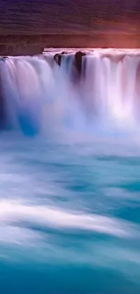 This live wallpaper features a mesmerizing waterfall in the center of a vast body of water, creating a soothing and tranquil atmosphere