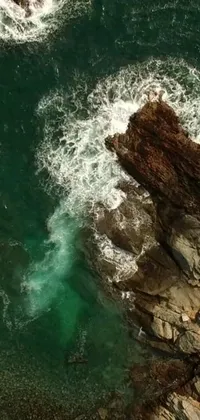 Immerse yourself in the breathtaking beauty of a rocky coastline with this phone live wallpaper