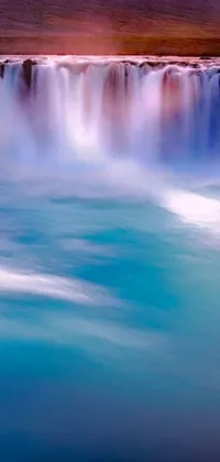 This phone live wallpaper features a stunning waterfall set in a vast body of water in a lyrical abstraction style