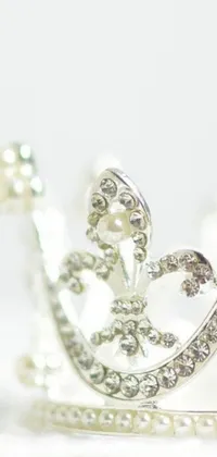 This ultra detailed phone live wallpaper features a silver crown with pearls atop a white table