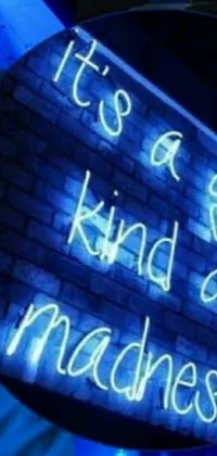 This phone live wallpaper features a stunning neon sign that reads "It's a Good Kind of Madness" with a trendy blue lighting effect