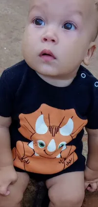 This phone live wallpaper features an adorable baby wearing a t-shirt with a cartoon cat design on it, set against a colorful, vibrant cityscape inspired by Sao Paulo