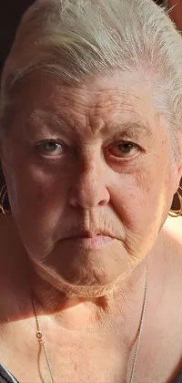This phone live wallpaper showcases a realistic portrait of an elderly person wearing a necklace, with sunlight washing over their wrinkled skin adding texture and depth