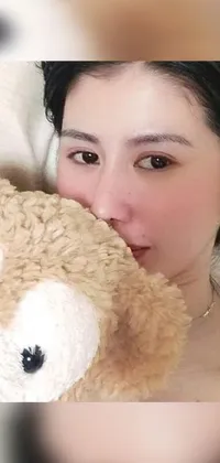 This multi-faceted phone live wallpaper portrays a peaceful moment of a woman resting in bed with a plush bear and picture frame nearby