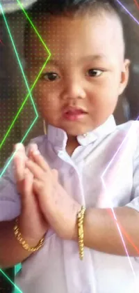 This phone live wallpaper features an adorable young boy standing with his hands together
