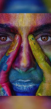 This phone live wallpaper displays a beautiful and detailed painting of a man covering his face with painted hands
