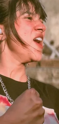 This live wallpaper features a person grasping a cell phone, wearing a bandana and chain, in a white tank top and sporting a plaster on the cheek