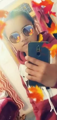 Add some life to your phone's display with this wonderful live wallpaper design! This phone wallpaper showcases an animated woman taking a selfie with her orange sunglasses while holding a phone