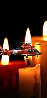 If you're looking for a unique mobile wallpaper, this helicopter and candle live wallpaper might be just what you need! The image is a beautiful piece of digital art featuring a helicopter hovering over a lit candle on a table, accompanied by a floating candle that adds to the warm glow of the scene