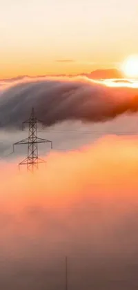 This live phone wallpaper showcases a power line in a sea of clouds during sunrise over a solarpunk city