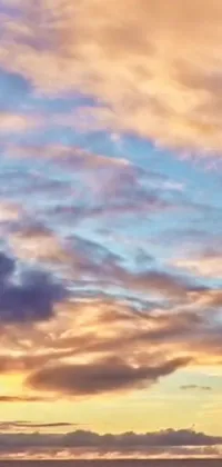 This phone live wallpaper showcases an incredible scene of a surfing man riding the waves on a sandy beach, with a breathtaking sunset and massive clouds in the background