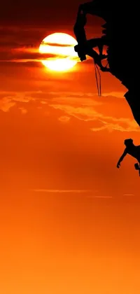 This phone live wallpaper showcases a breathtaking silhouette of a rock climber against a stunning sunset background