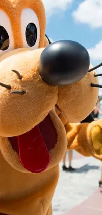 This phone live wallpaper depicts an adorable dog, Pluto, standing in front of a happy crowd