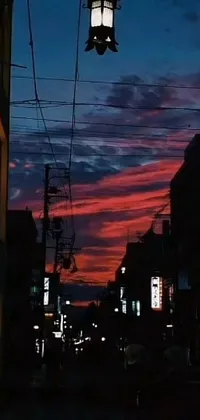 Decorate your phone screen with a beautiful live wallpaper featuring an enchanting street light against a backdrop of a breathtaking sōsaku hanga-inspired red-pink sunset