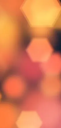 This live phone wallpaper showcases blurry light clusters against a pink and orange background, with hexagonal shapes adding depth