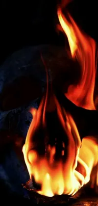 This phone live wallpaper showcases a digital artwork of a close-up view of fiery flames with striking orange and yellow hues