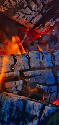 This phone live wallpaper showcases an up-close view of a blazing fire in a rustic fireplace