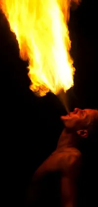 This phone live wallpaper depicts a powerful man standing in front of a blazing fire