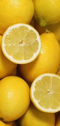 Looking for a visually refreshing phone live wallpaper? Look no further! This stunning wallpaper features a pile of lemons, with one of them cut in half, presenting their yellow and juicy flesh