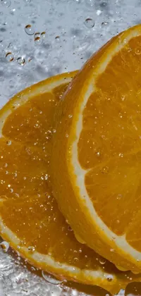 This colorful live wallpaper features two oranges resting on a wooden table