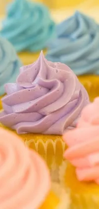 Indulge in the eye-catching wallpaper, showcasing delicious cupcakes with pastel frosting sitting on a plate
