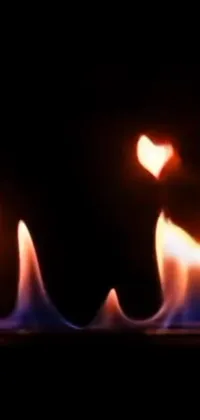 This phone live wallpaper features a mesmerizing close-up of a red-hot and crackling fire with a radiant heart shape on it