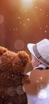 This phone wallpaper displays a delightful image of a baby sitting beside a brown teddy bear